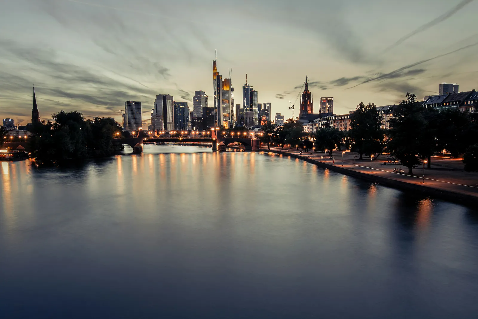 Beleuchtete Frankfurter Bankenskyline am Main in warmer Abenddämmerung
